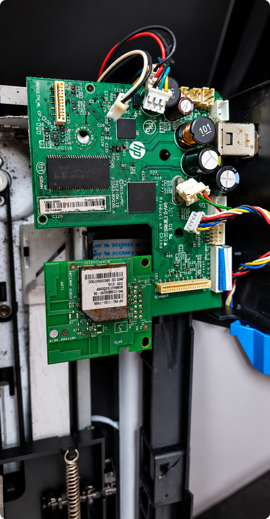 Close-up of an HP printer formatter board during a component-level repair
